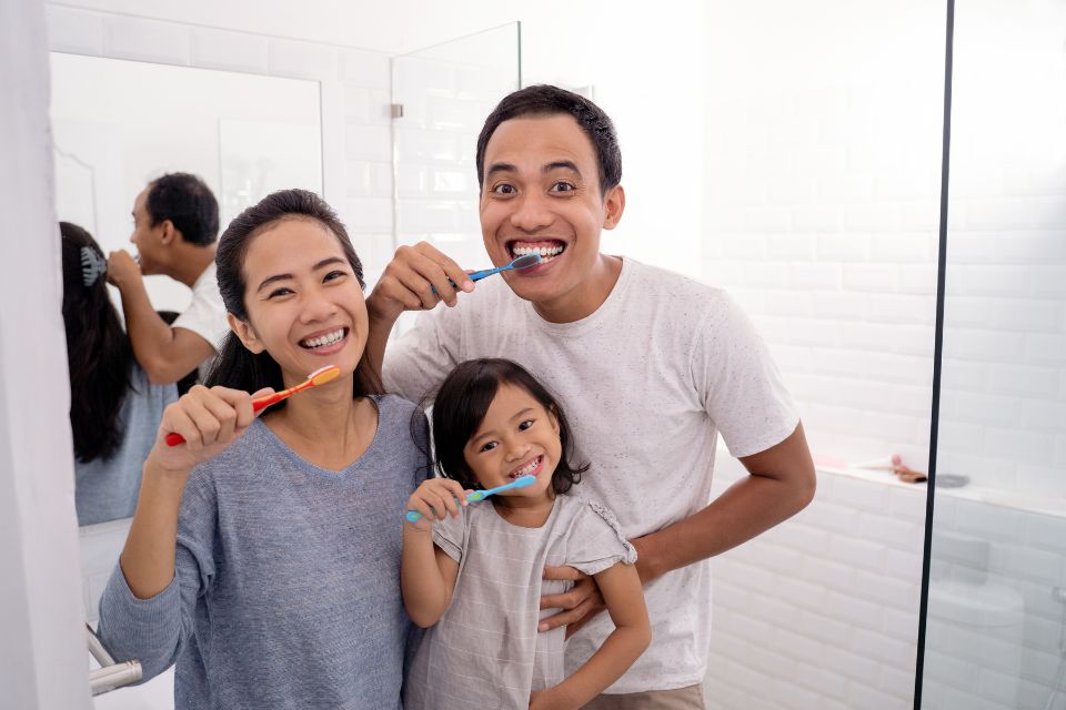asian family brushing teeth
