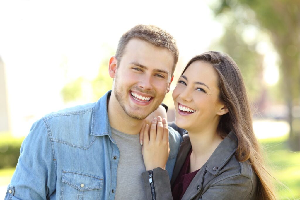 young couple smiling together at the park