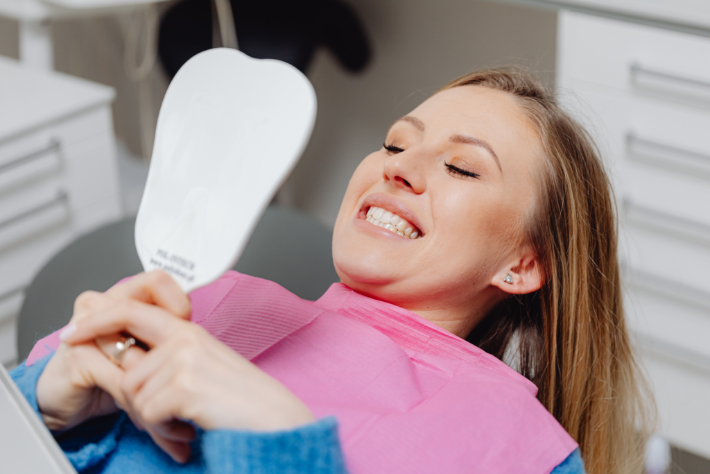 woman inspecting her teeth at dentist