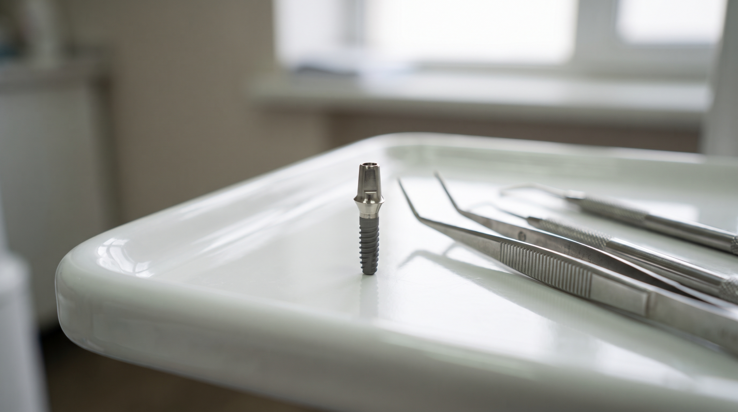 Close up of a titanium dental implant post and abutment on a sterile dental tray